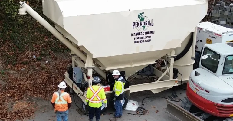 3 construction standing around a PD800 grout silo.